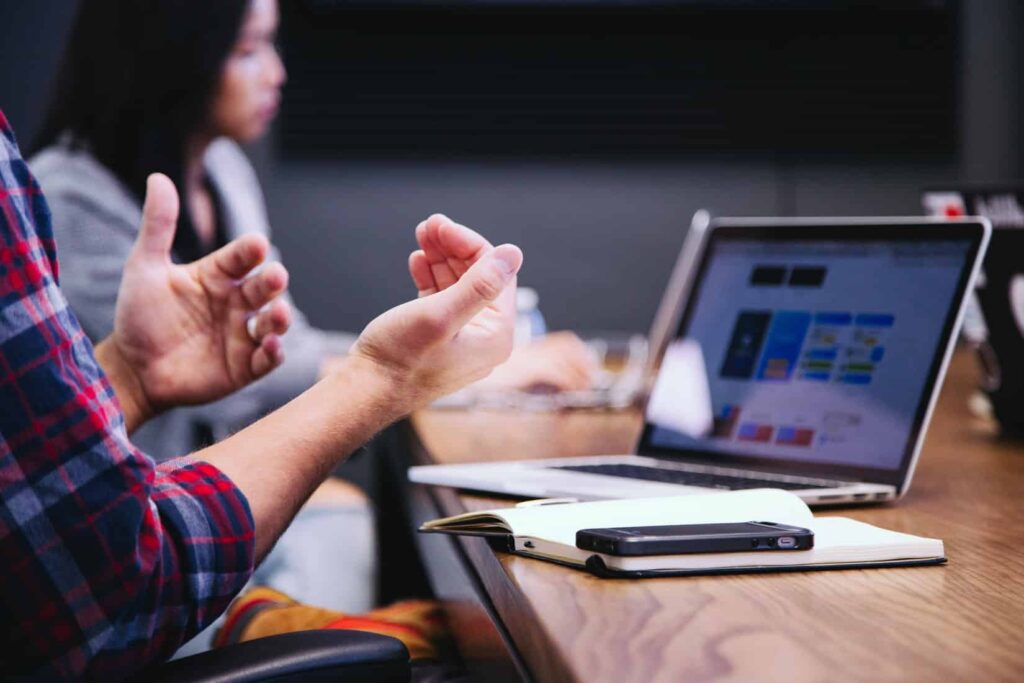 Échange autour d'une table de travail avec un ordinateur portable